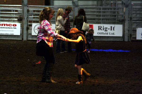 A pair of cowgirls stomp up a storm at the Dance in the Dirt event at the Black Gold Rodeo A pair of cowgirls stomp up a storm at the Dance in the Dirt event at the Black Gold Rodeo